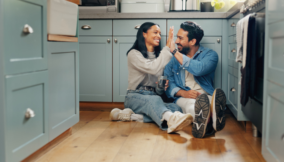 couple on floor of kitchen high fiving